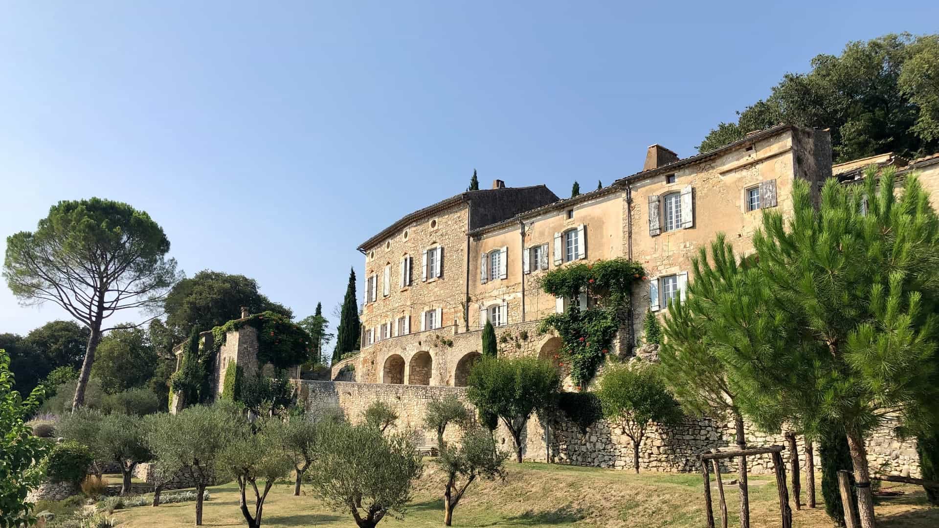 Sunlit French stone estate above an olive grove in the South of France