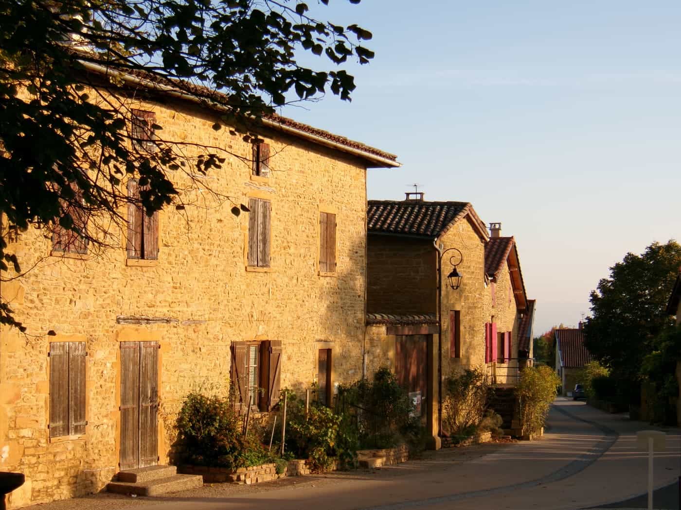 A golden stone village street in low evening sun