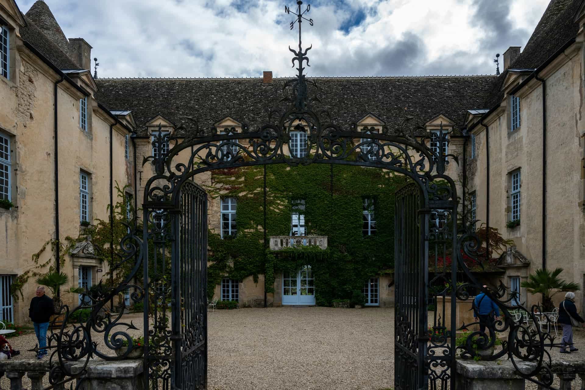 Wrought iron estate gate in a sunlit French courtyard